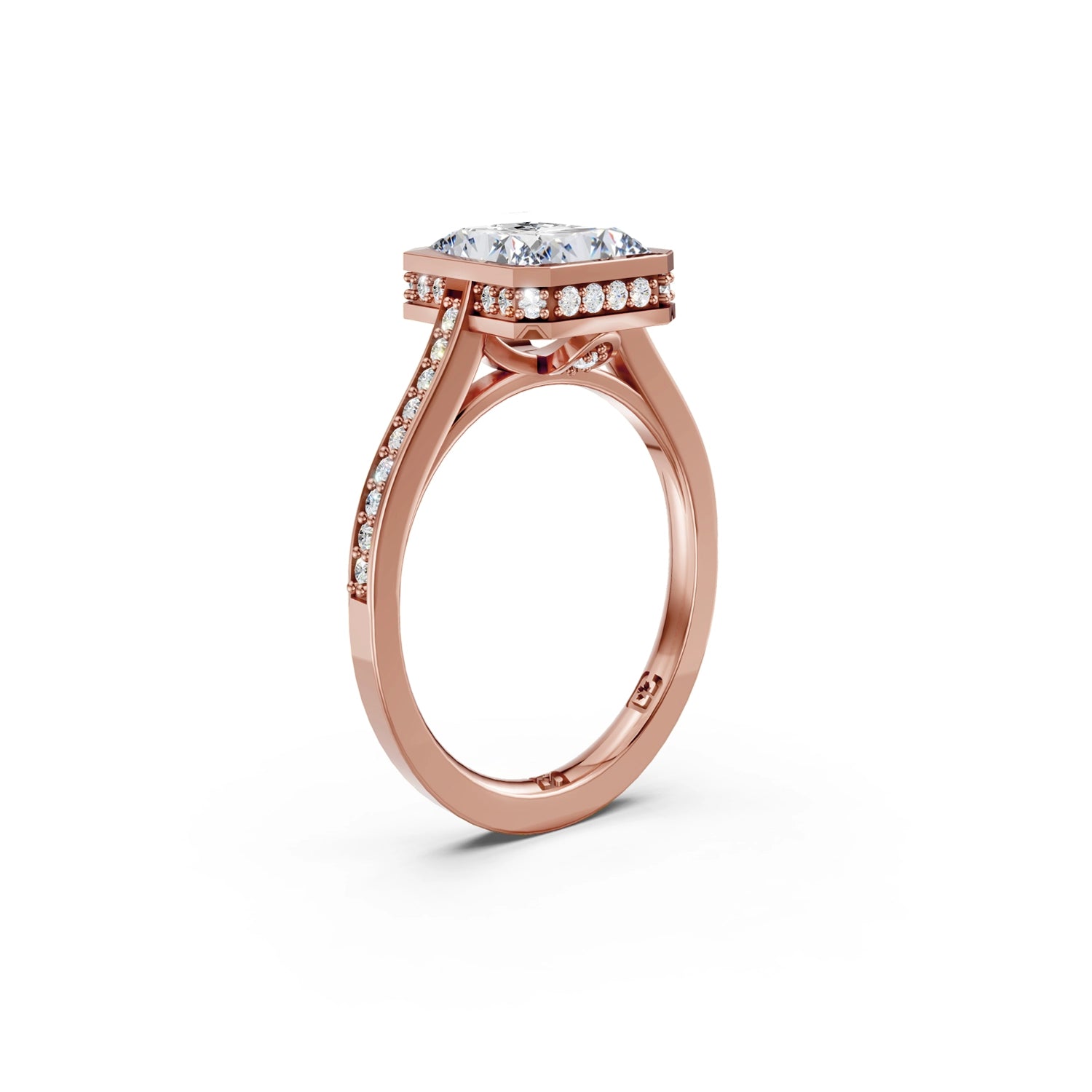 Beautiful pink gold radiant diamond bezel engagement ring with hidden halo, 2 carat centre diamond and a row of bright, white diamonds running down the engagement ring band on white background. Made in Canada. Bague fiançailles à diamants avec halo caché et diamants sur l'anneau sur fond blanc. Fabriquée à Montréal. Style serti clos.