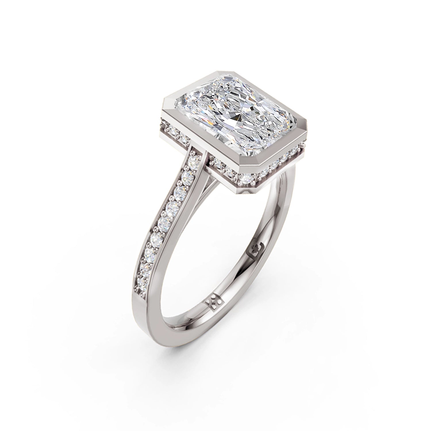 Beautiful white gold or platinum radiant diamond bezel engagement ring with hidden halo, 2 carat centre diamond and a row of bright, white diamonds running down the engagement ring band on white background. Made in Canada. Bague fiançailles à diamants avec halo caché et diamants sur l'anneau sur fond blanc. Fabriquée à Montréal. Style serti clos.
